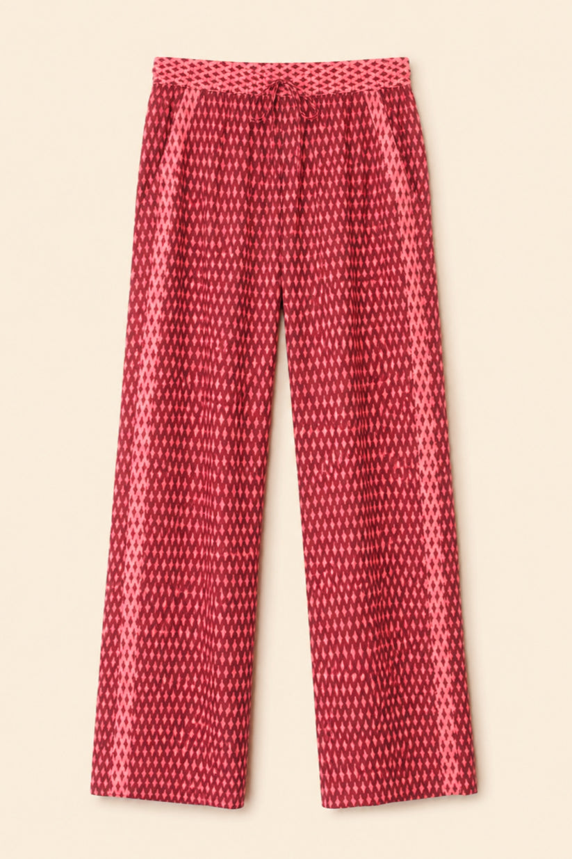Red and pink patterned wide-leg pants with a drawstring waist, shown flat against a light beige background.