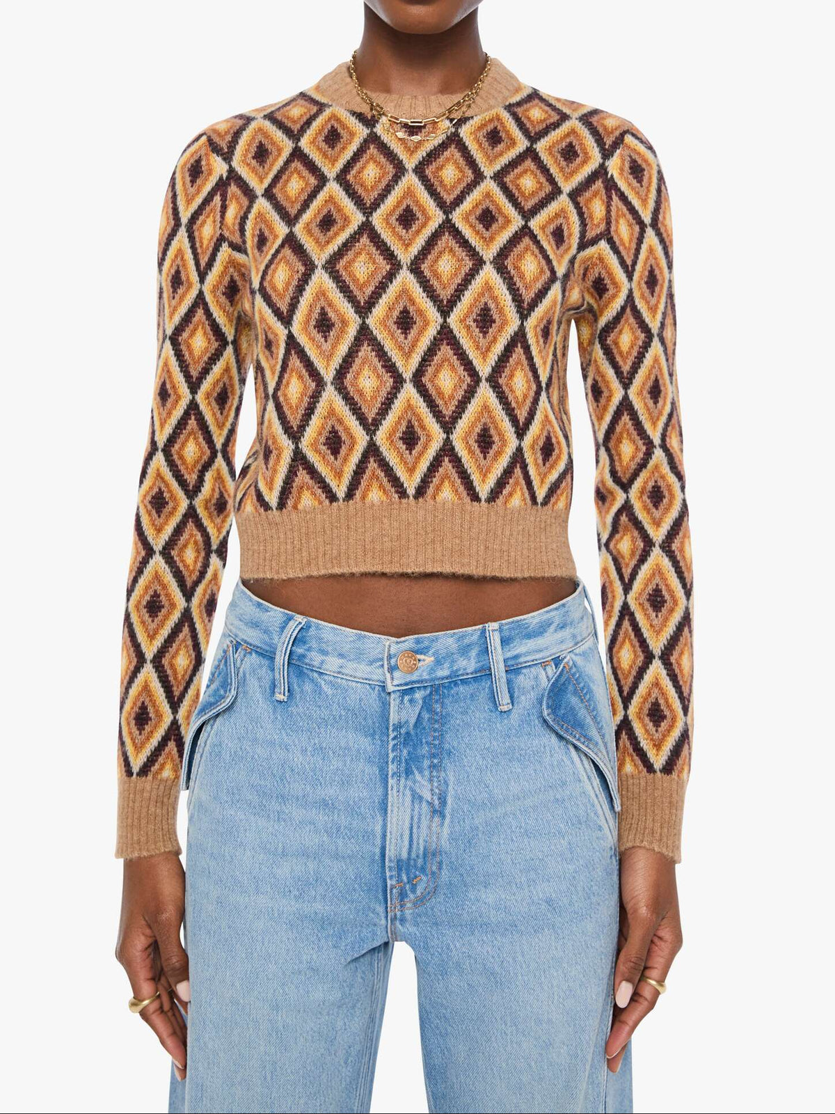 Woman wearing a patterned sweater and jeans on a white background