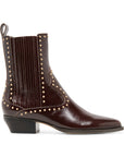 A dark brown leather ankle boot with a pointed toe, black block heel, and gold-tone metal studs, shown from a side profile on a white background.