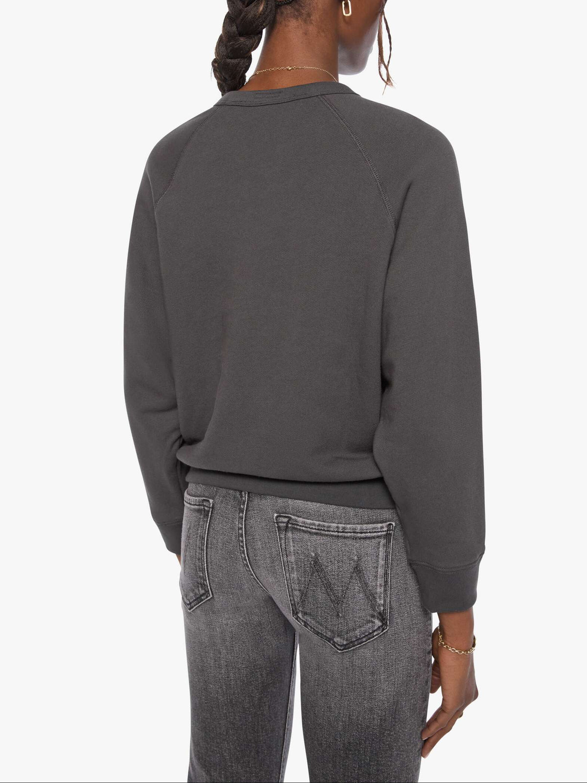 Person wearing a dark gray sweatshirt and jeans on a white background