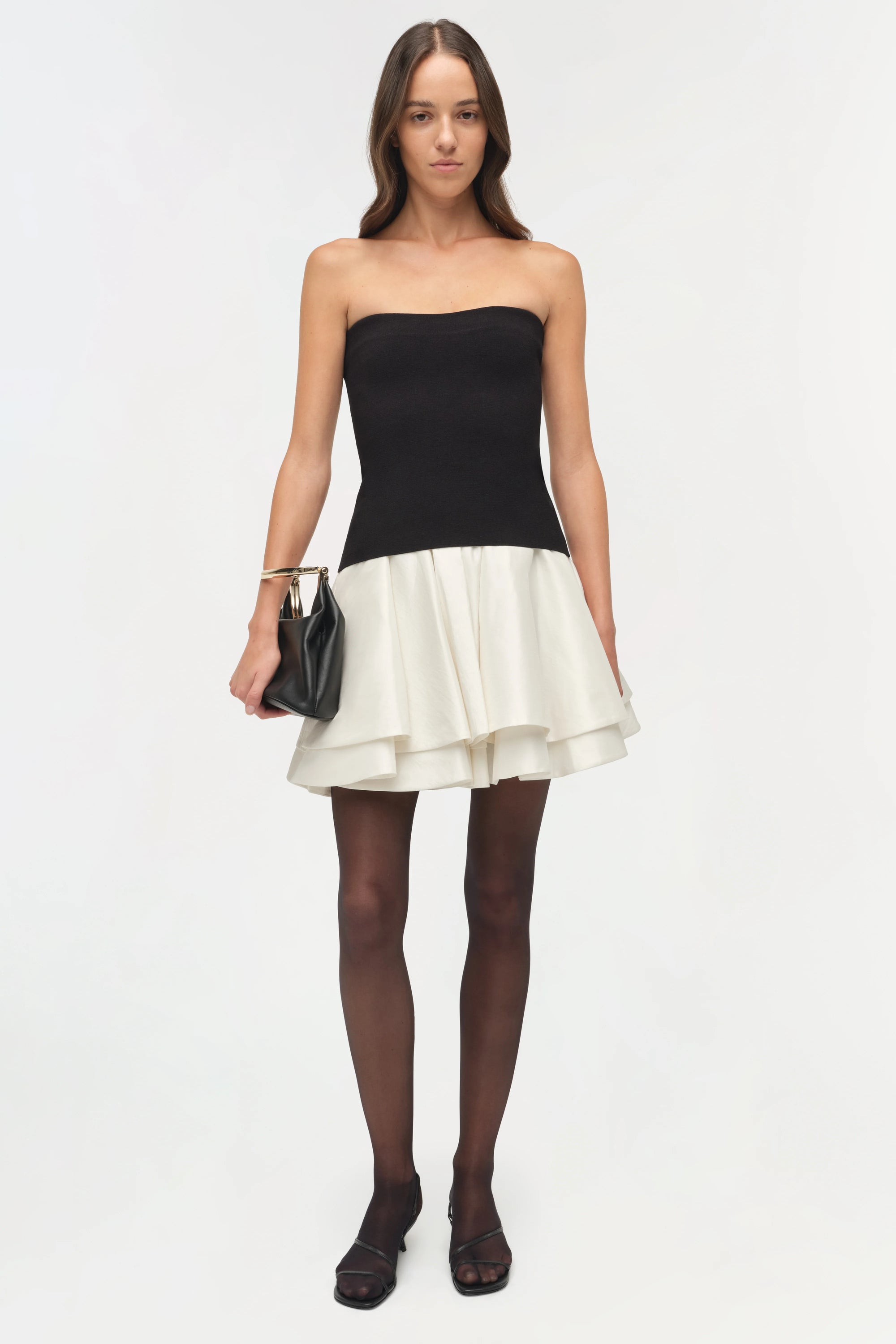 Isabelle Taffeta Knit Mini Dress on a model  holding a black bag with a white background, front