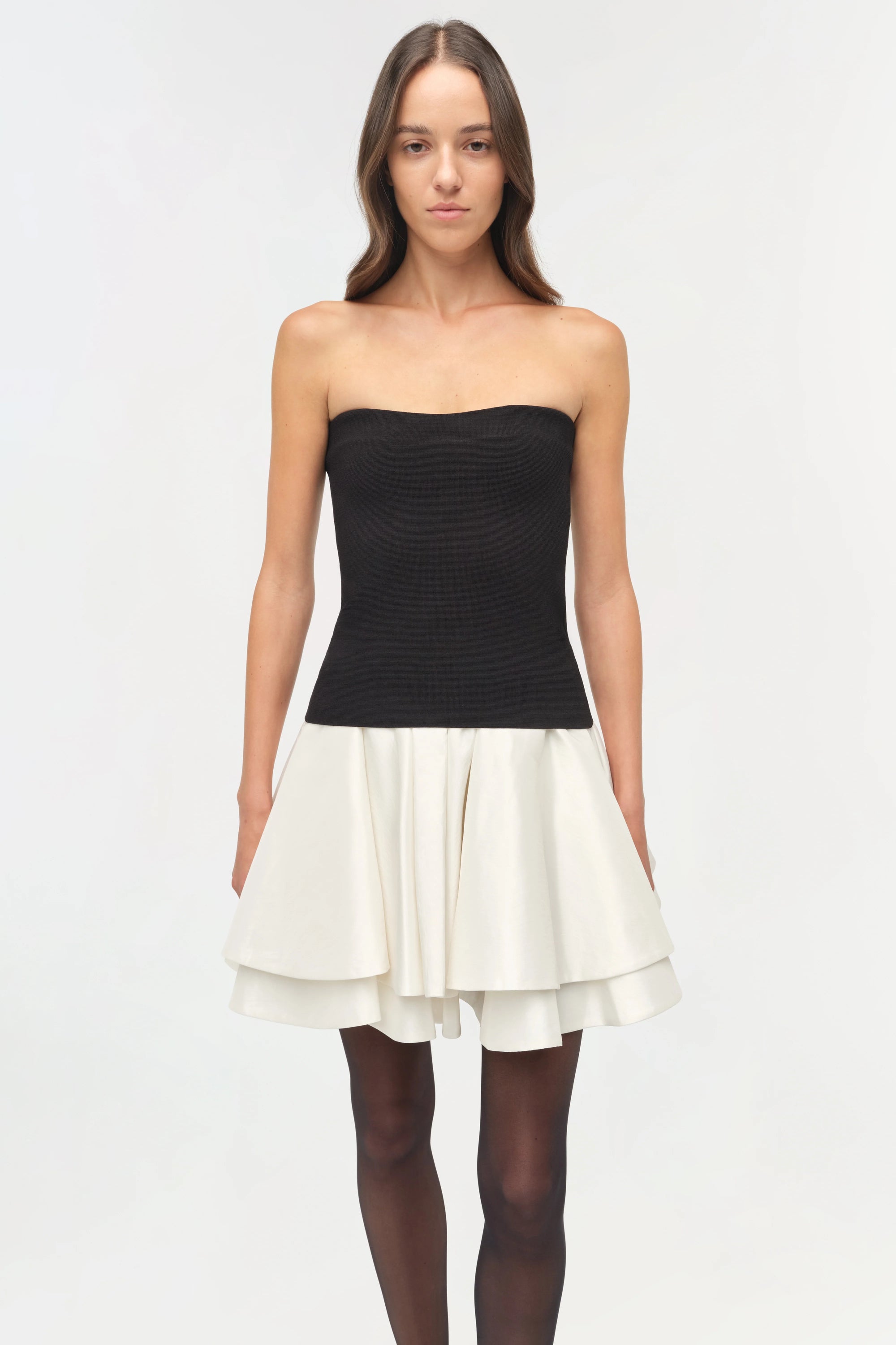 Isabelle Taffeta Knit Mini Dress on a model  holding a black bag with a white background