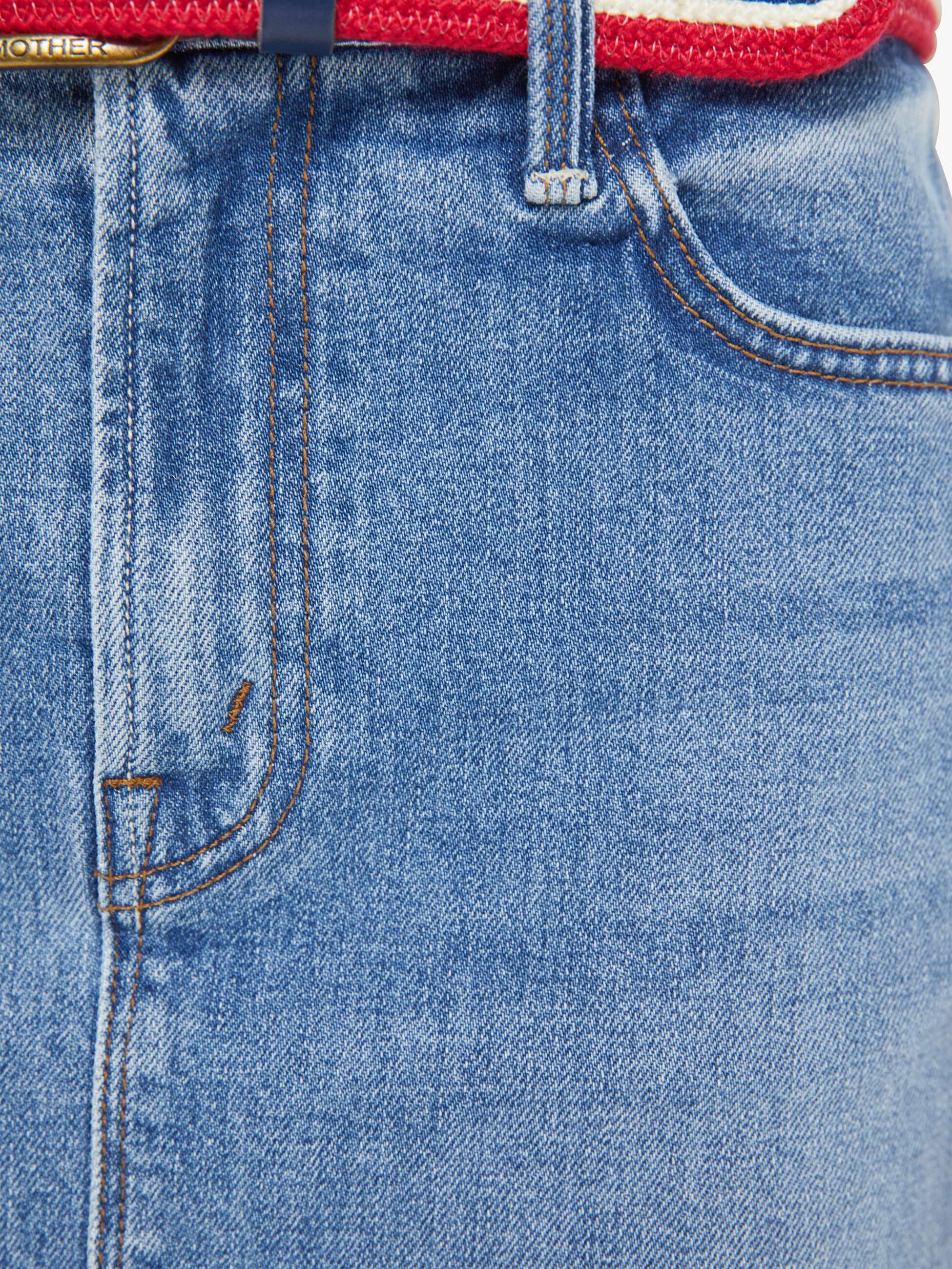 Close-up of blue jeans with a red and blue belt.