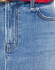 Close-up of blue jeans with a red and blue belt.