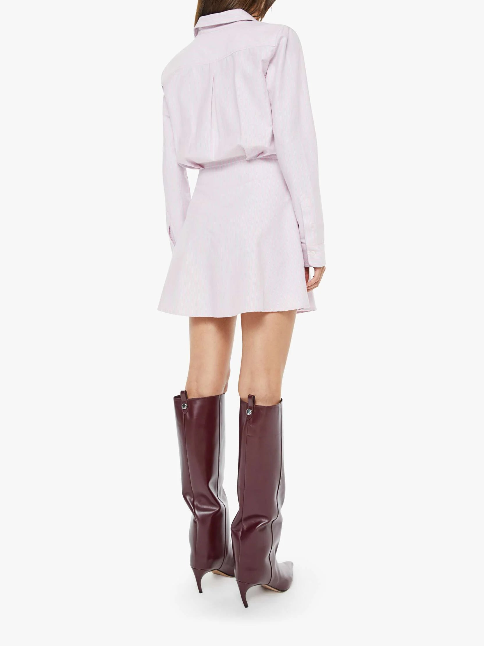 Woman wearing a light purple dress and high boots on a white background
