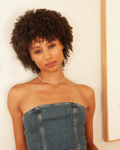 Woman wearing a strapless denim dress and 90s Baby Chain Necklace against a plain background