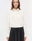 Woman wearing a white blouse with black pleated skirt on a white background