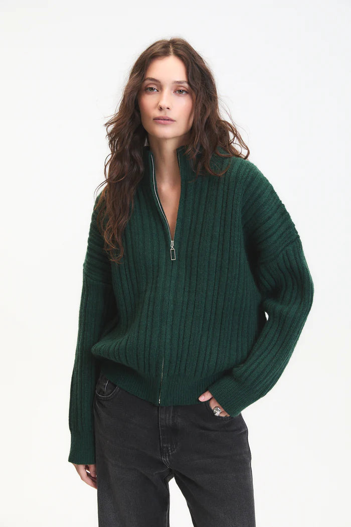 Woman wearing a green sweater with a zipper on a white background
