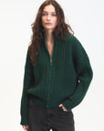 Woman wearing a green sweater with a zipper on a white background