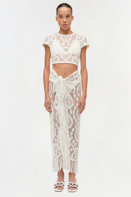 Woman wearing a white lace outfit on a white background