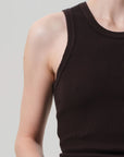 Person wearing a black ribbed tank top against a gray background