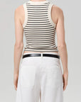 Person wearing a black and white striped tank top with a plain background