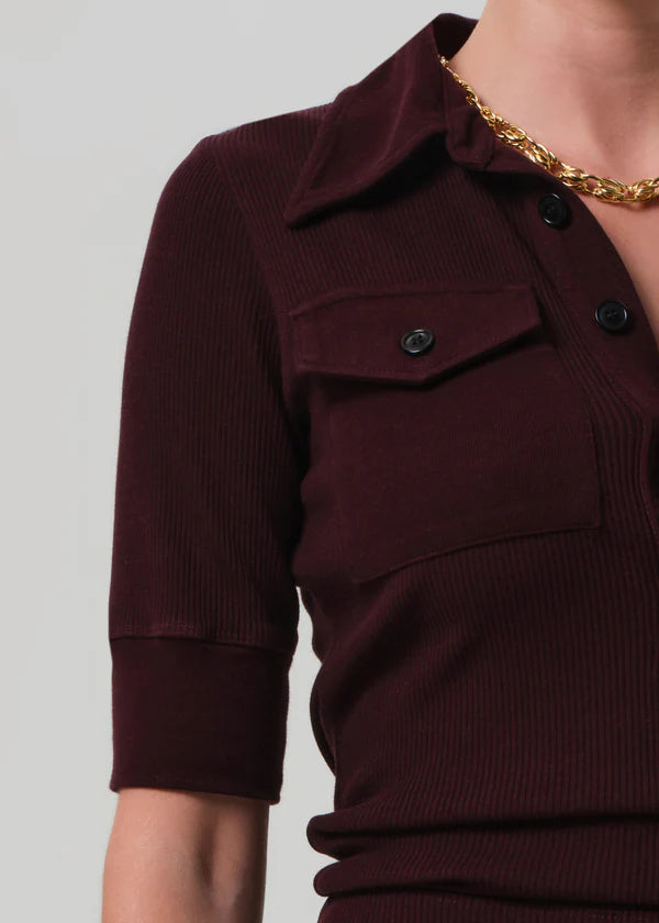 Close-up of a maroon ribbed sweater with a plain background detail view