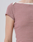 Close-up of a person wearing a short-sleeve ribbed top with horizontal red and off-white stripes, cropped from the neck to the upper torso against a light gray background.