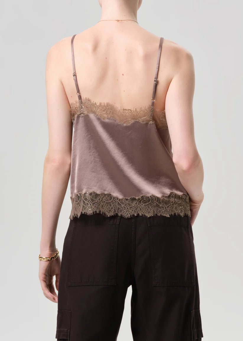 Person wearing a lace-trimmed tank top and cargo pants on a plain background