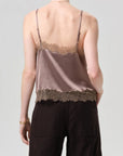 Person wearing a lace-trimmed tank top and cargo pants on a plain background