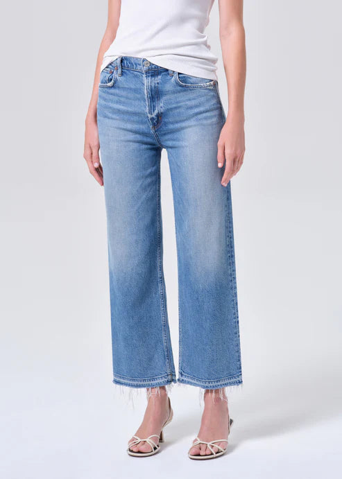 Person wearing light blue jeans on a white background