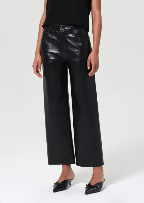 Person wearing black leather pants on a white background