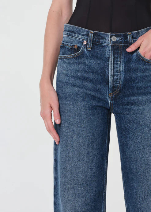 Blue jeans worn by a person on a light gray background