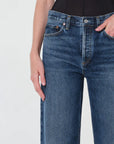 Blue jeans worn by a person on a light gray background