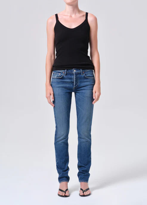 Person wearing a black tank top and blue jeans on a white background