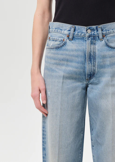 Light blue jeans worn by a person on a white background