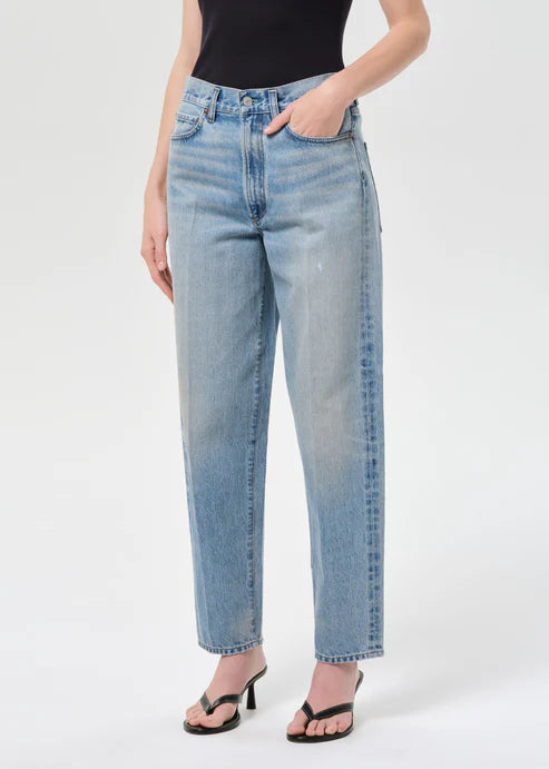 Person wearing light blue jeans on a white background