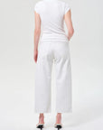 Person wearing a white t-shirt and white pants on a white background
