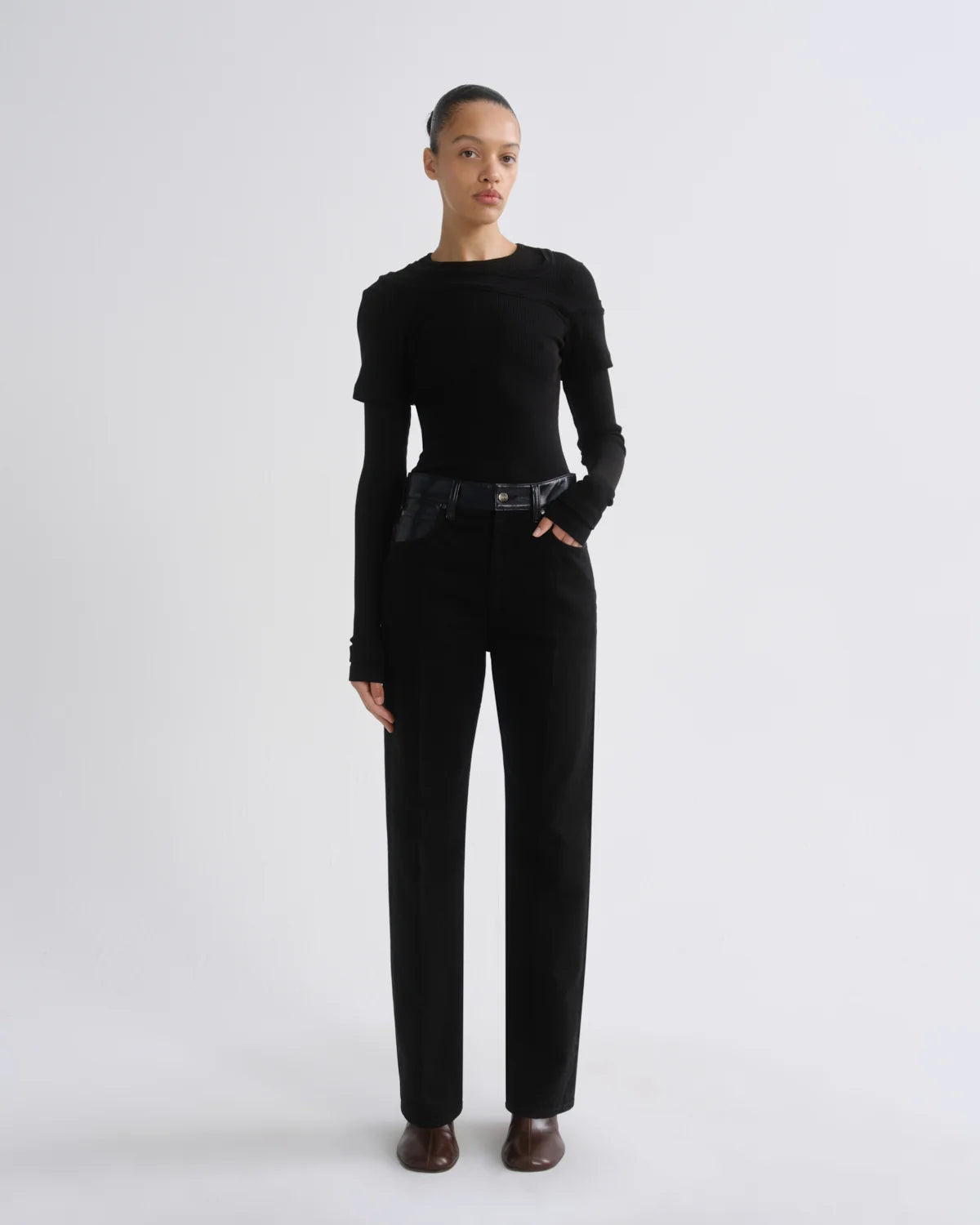 model wearing black jeans and a black top on a white background 