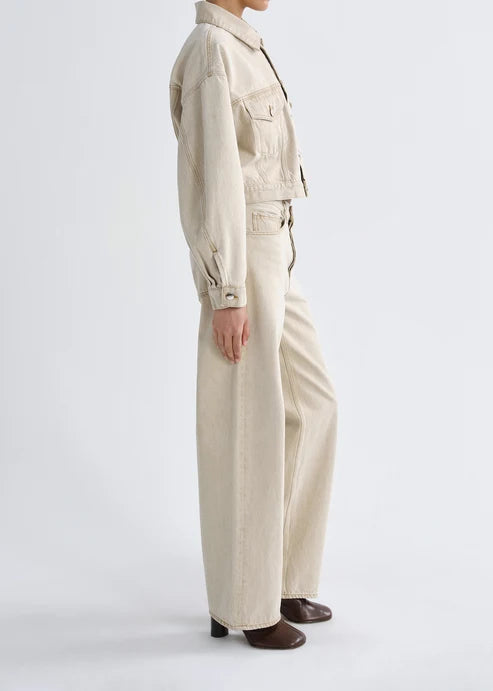 Person wearing a beige jumpsuit on a white background