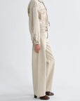 Person wearing a beige jumpsuit on a white background