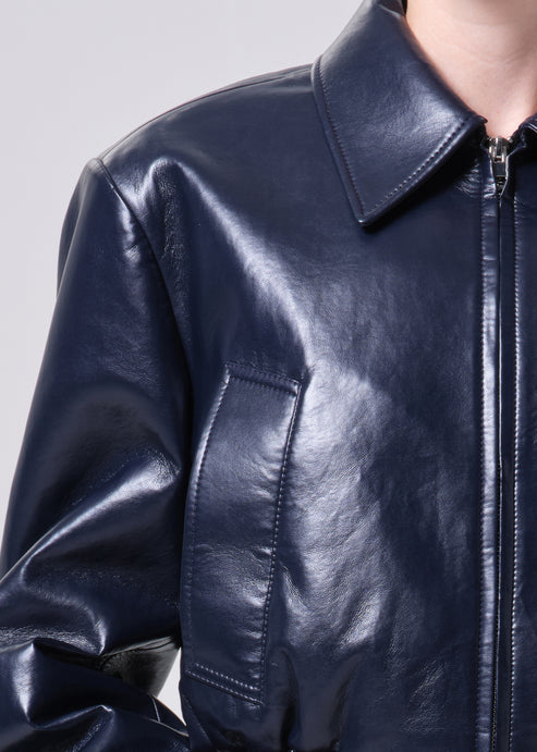 Close-up of a dark blue leather jacket on a plain background
