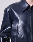 Close-up of a dark blue leather jacket on a plain background
