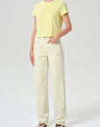 Person wearing a yellow t-shirt and light-colored pants on a white background