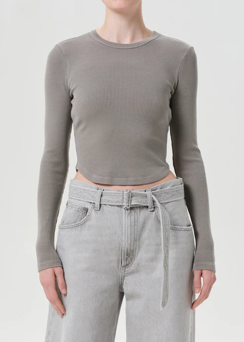 Person wearing a gray ribbed long-sleeve top and light gray jeans on a white background, front