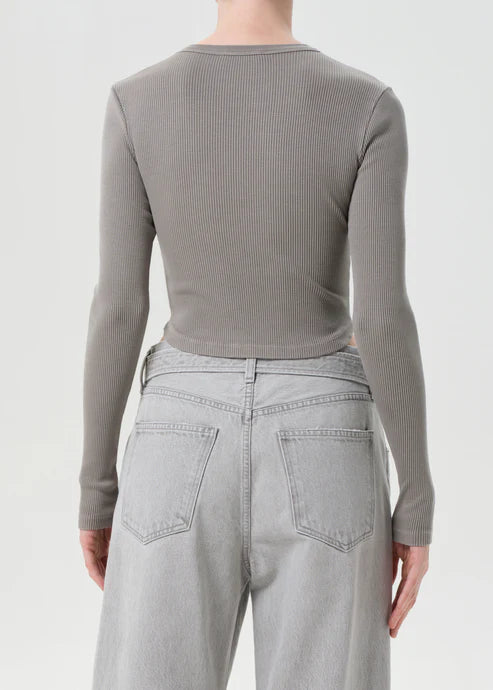 Person wearing a gray ribbed long-sleeve top and light gray jeans on a white background, back