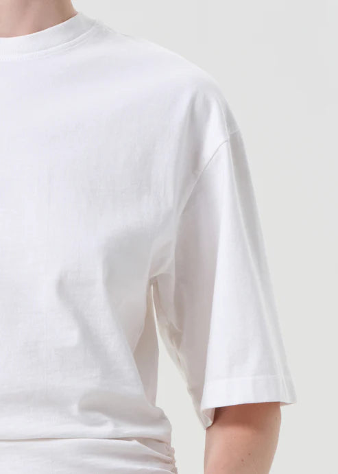 White t-shirt worn by a person on a plain background