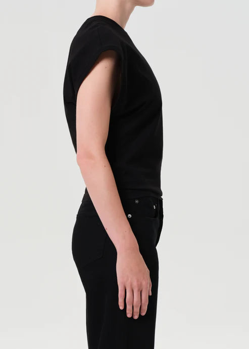 Person wearing a black outfit on a light gray background