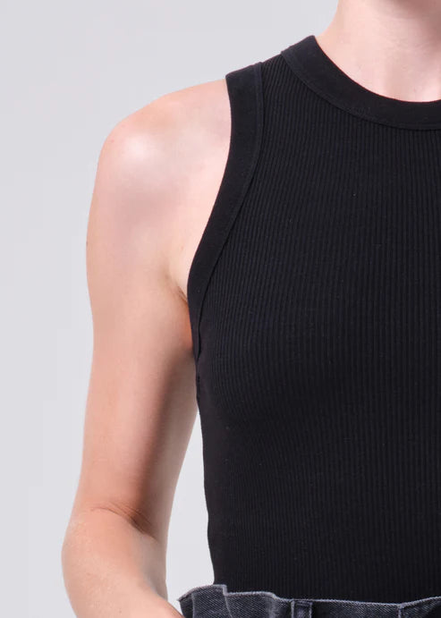 Black sleeveless top worn by a person on a light gray background