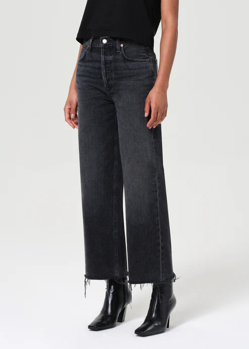 Person wearing black jeans and black boots on a white background