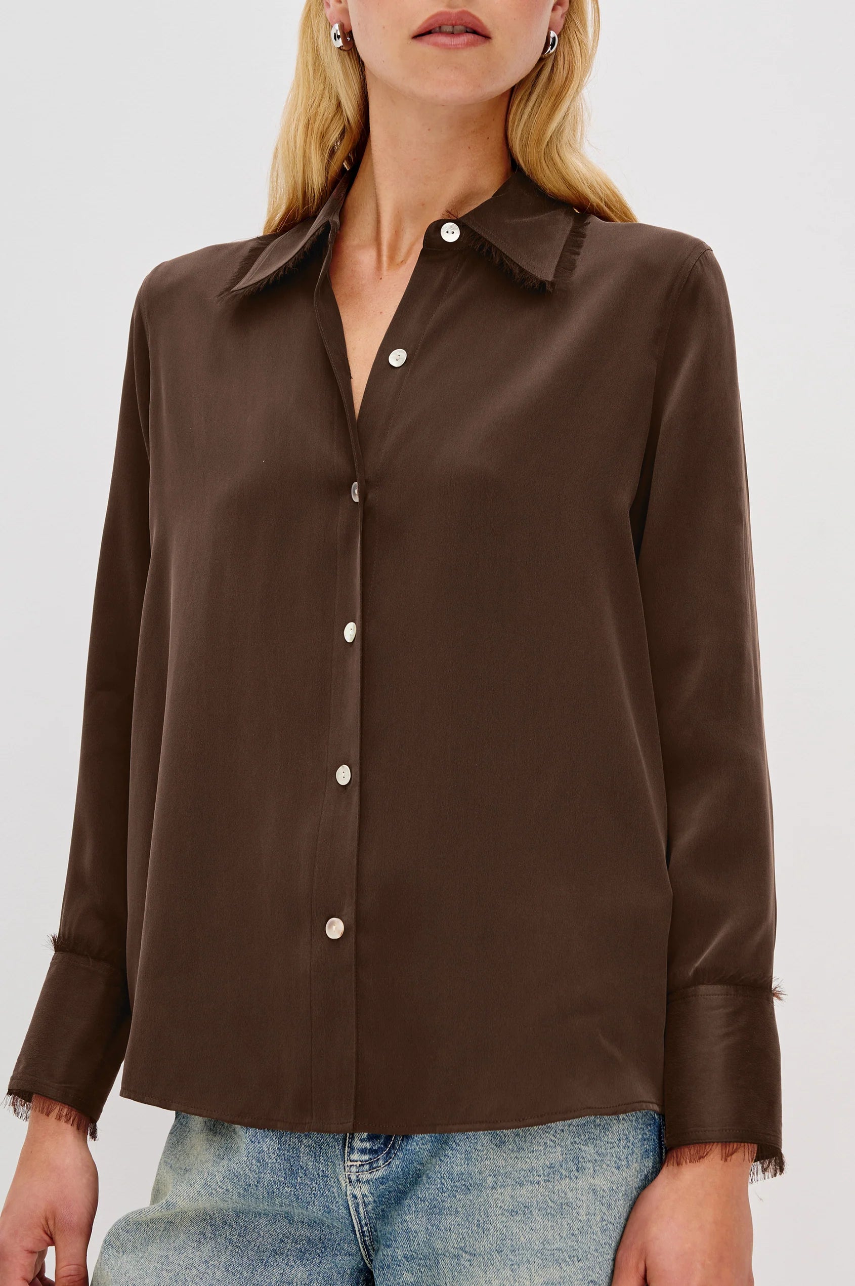 Brown button-up shirt worn by a person on a white background