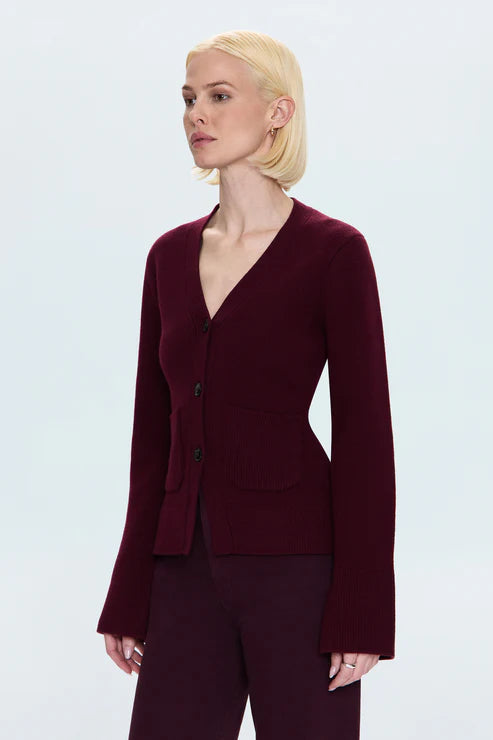 Woman wearing a burgundy cardigan on a white background side