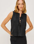 Woman wearing a black sleeveless top with a bow detail on a white background