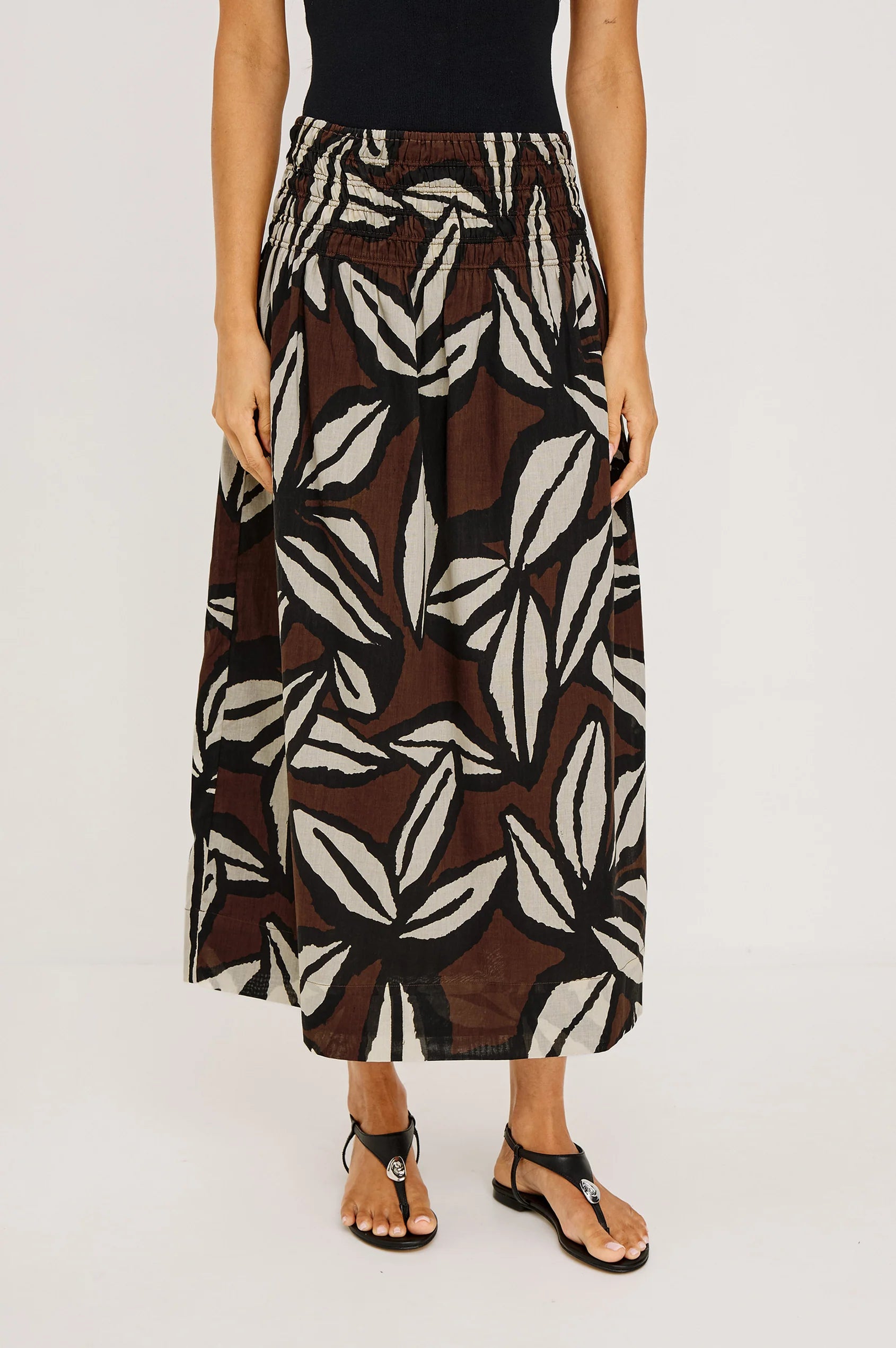 Person wearing a patterned skirt on a plain background