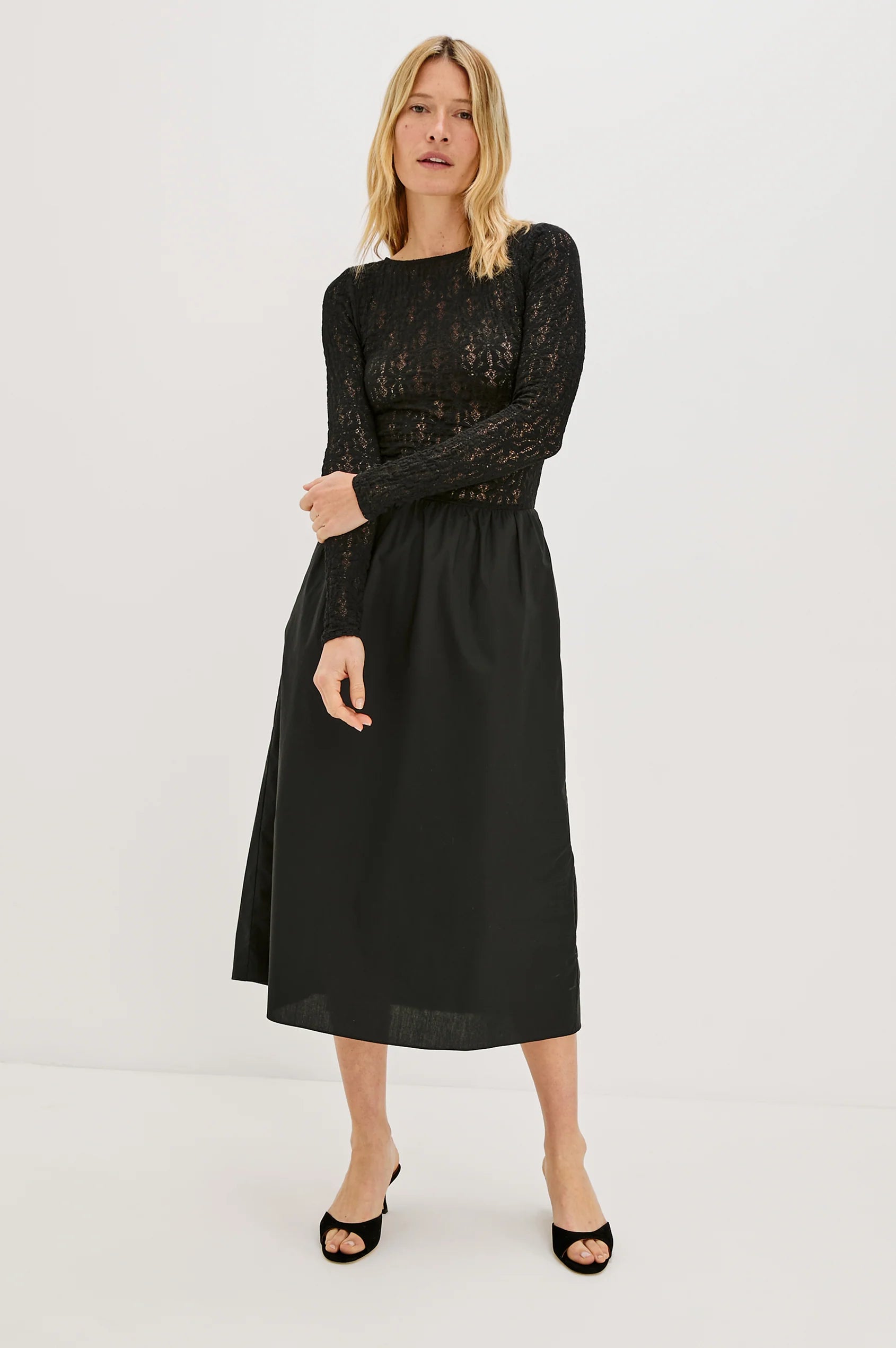 Woman modeling a black dress with lace on white background front view