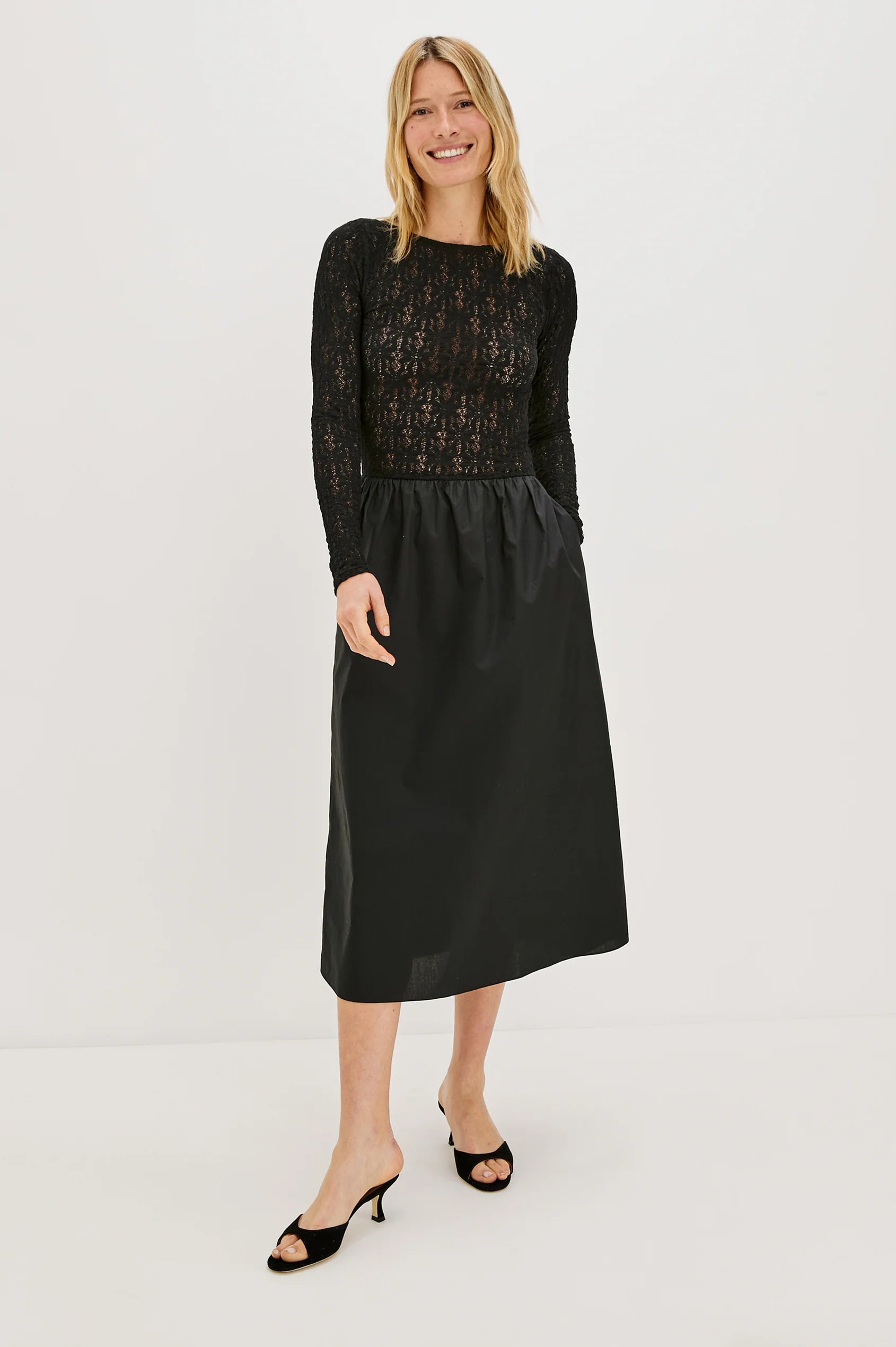 Woman modeling a black dress with lace on white background front view