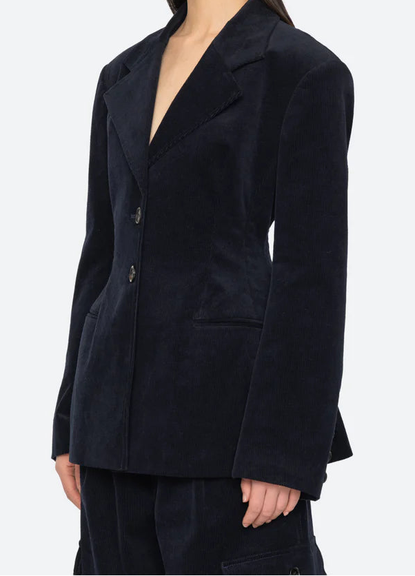 Woman wearing a dark blue blazer against a white background
