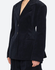 Woman wearing a dark blue blazer against a white background
