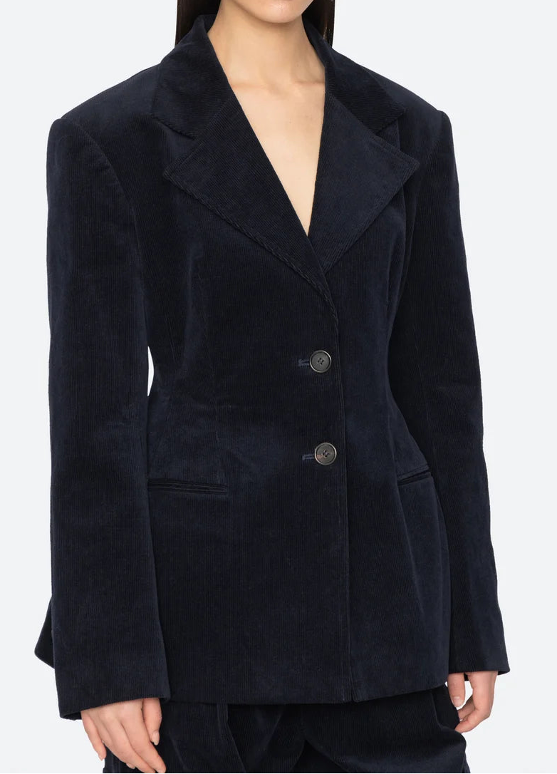 Navy blue blazer worn by a model on a white background