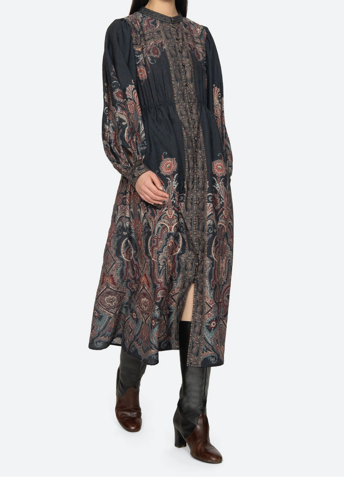 Woman wearing a long, patterned dress on a white background